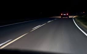 a road at night with a car in the distant 