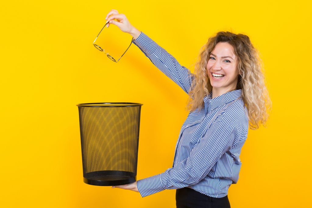 Woman throwing away her glasses after LASIK